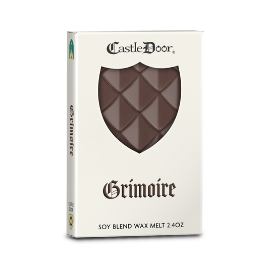 Castle Door Grimoire dragonscale wax melt in white book-style packaging, with dark brown dragonscale wax visible through a shield-shaped window.