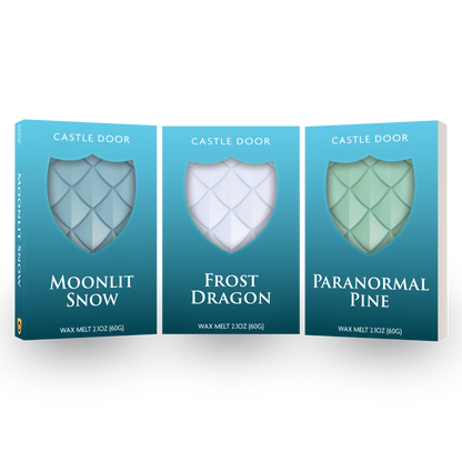 Castle Door Eternal Winter Wax Melt Trilogy featuring Moonlit Snow, Frost Dragon, and Paranormal Pine in teal boxes with dragonscale wax visible through shield windows.