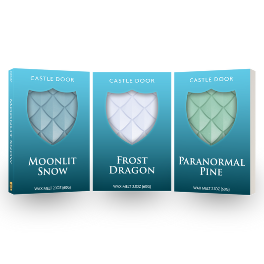 Castle Door Eternal Winter Wax Melt Trilogy featuring Moonlit Snow, Frost Dragon, and Paranormal Pine in teal boxes with dragonscale wax visible through shield windows.