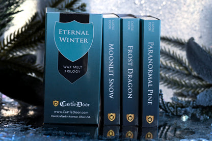 Eternal Winter Wax Melt Trilogy collector's box displayed beside the Moonlit Snow, Frost Dragon, and Paranormal Pine scent boxes in a snowy setting.