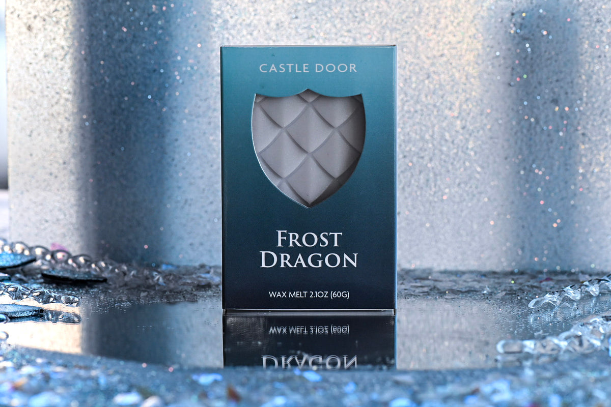 Frost Dragon wax melt box by Castle Door with white dragonscale wax visible through a shield window, photographed against a frosty background.