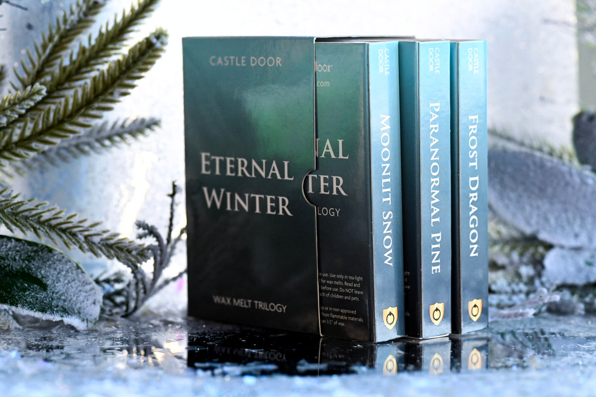 Rear view of the Eternal Winter Wax Melt Trilogy collector's box beside the three individual scent boxes in a snowy setting.